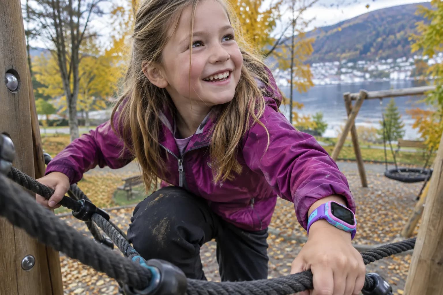 Barn som klatrer på lekeplassen med smartklokke og beskyttelsesdeksel